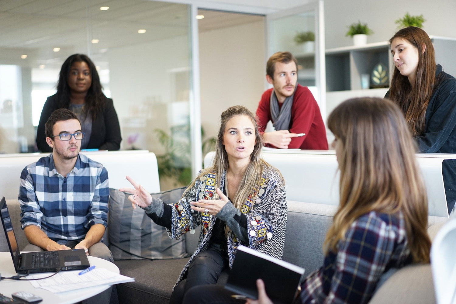 Team of coworkers having a discussion in a modern office lounge