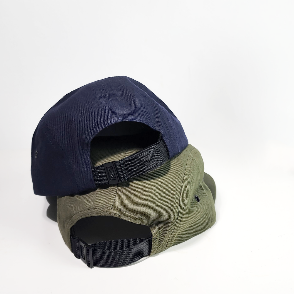 Back view of navy and olive Zest five-panel caps stacked showing adjustable straps