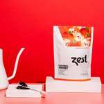 Zest Cinnamon Apple Loose Leaf pouch with gooseneck kettle and loose tea on red background