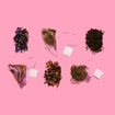 Six Zest tea varieties flat lay on pink background showing full flavor range