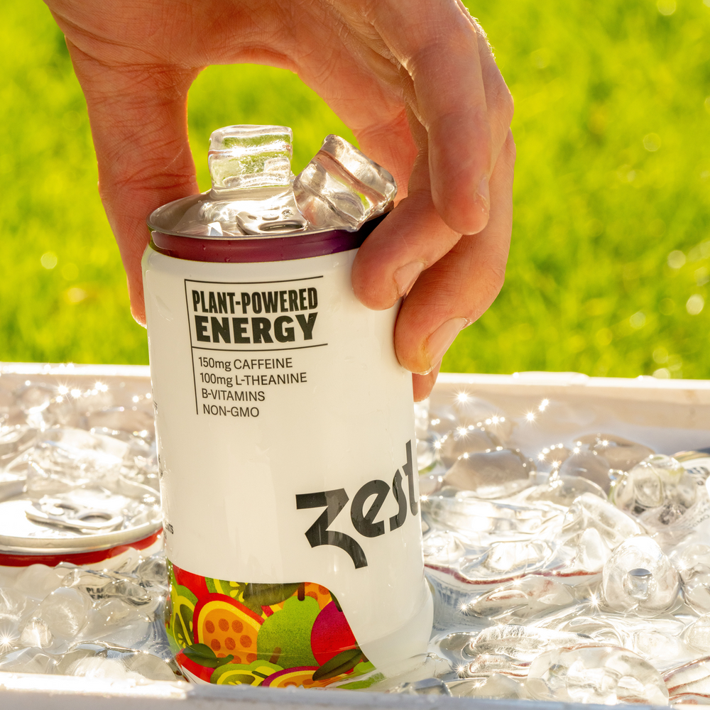 Hand grabbing Zest Passionfruit Berry sparkling can from ice cooler outdoors