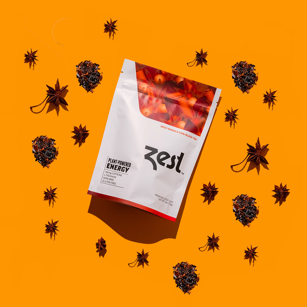 Zest Spicy Masala Chai loose leaf pouch with star anise and loose tea on orange background