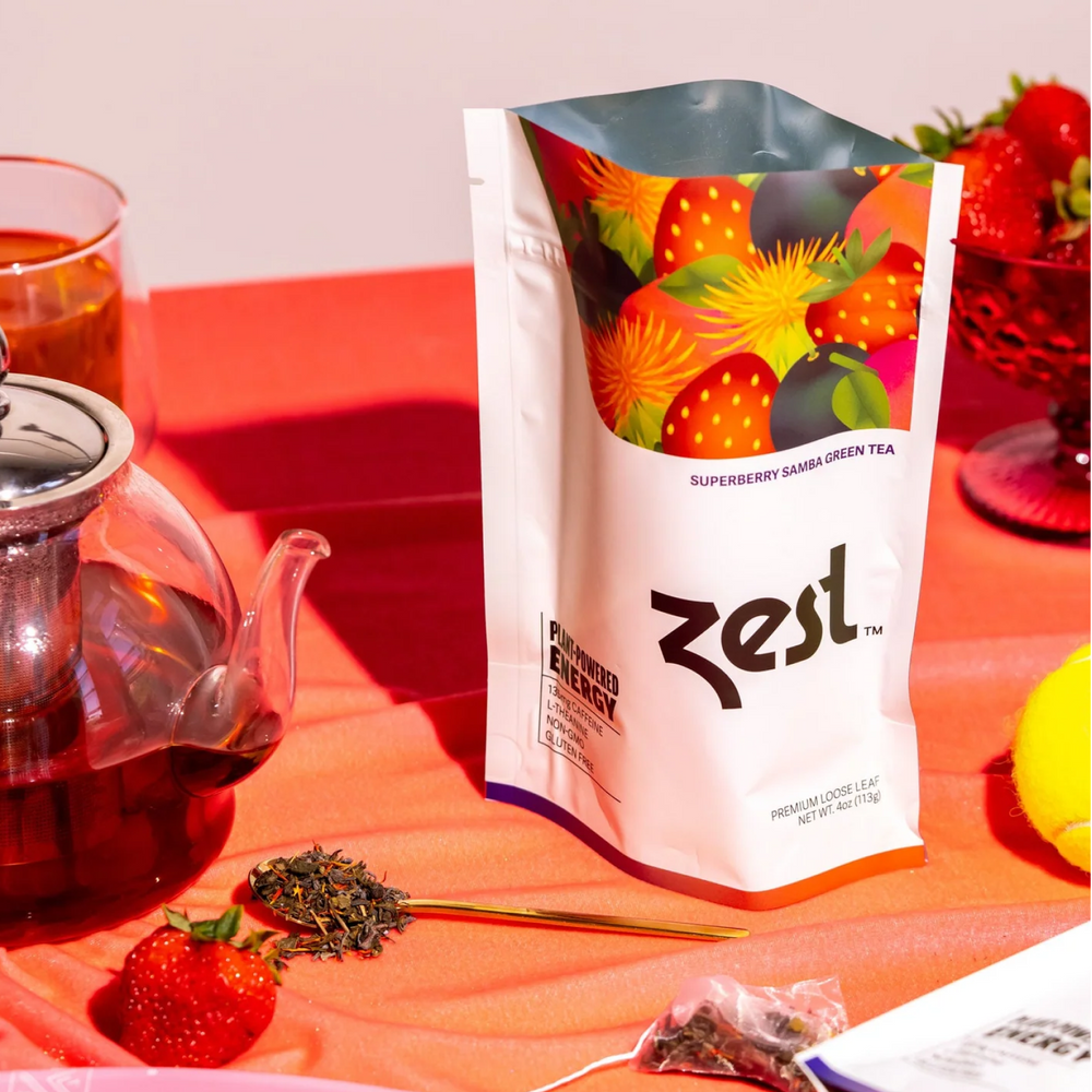 Zest Superberry Samba Loose Leaf pouch with glass teapot, strawberries, and loose tea lifestyle photo