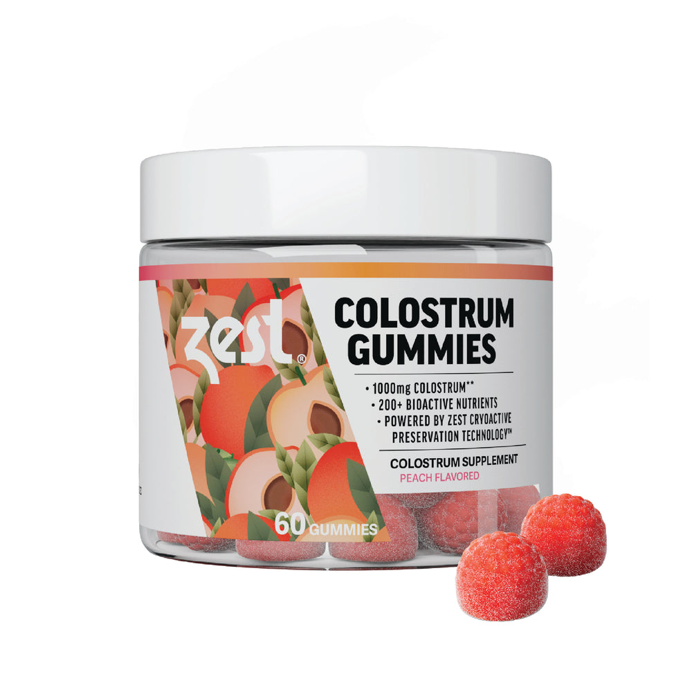 Zest Colostrum Gummies jar with loose gummies on white background