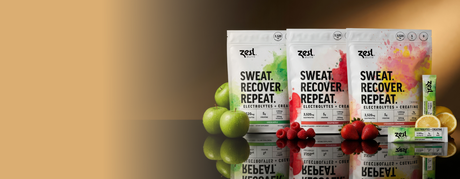 Zest Elite electrolytes and creatine drink mix pouches in Green Apple, Raspberry and Strawberry Lemonade, surrounded by fresh apples, raspberries, strawberries and lemon.