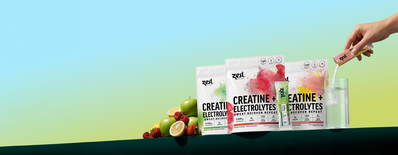 Zest Elite Creatine + Electrolytes pouches in Green Apple, Raspberry and Strawberry Lemonade with fresh fruit and a stick pouring into a glass of water